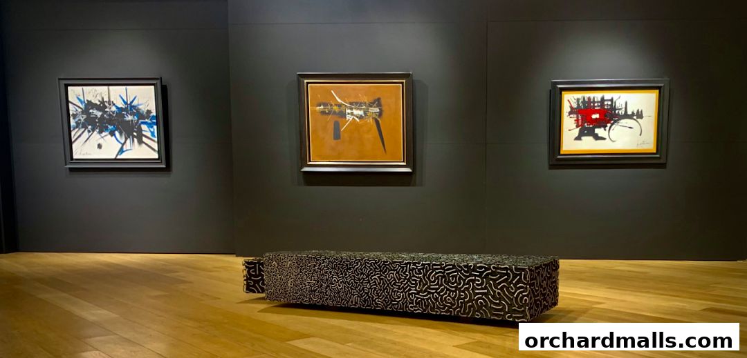 An art gallery interior with three framed abstract paintings and a decorative bench.