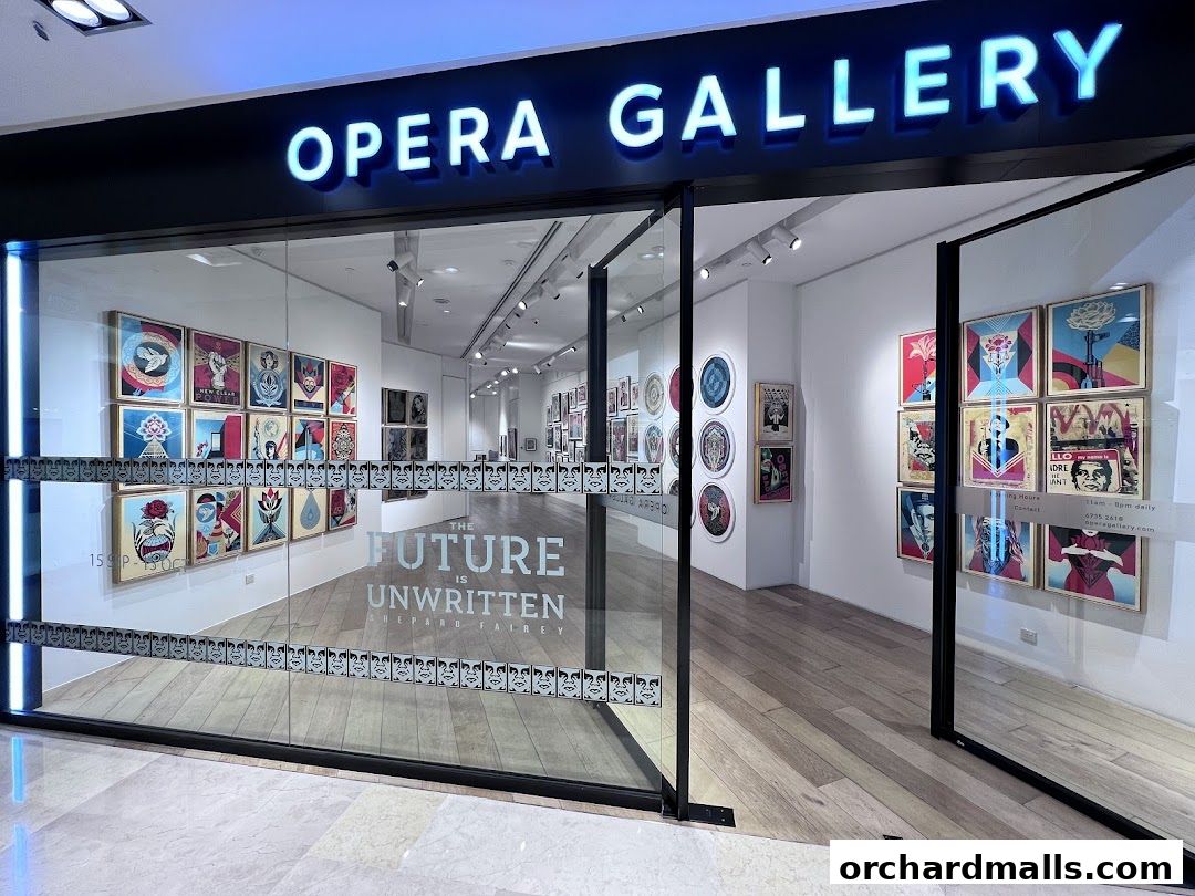 The entrance of Opera Gallery Singapore, showcasing vibrant artwork displayed on the walls and windows.