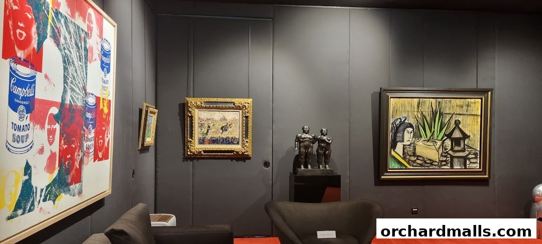 Interior view of an art gallery showcasing diverse artworks, including pop art and sculptures.