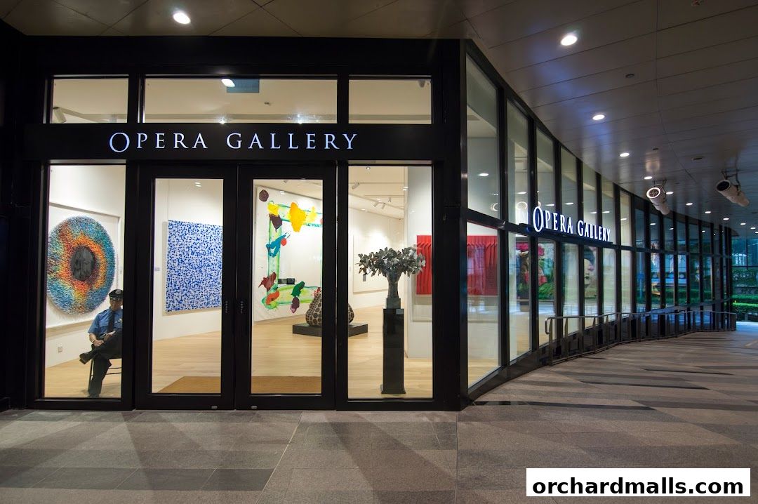 The Opera Gallery Singapore features a modern facade with large glass windows displaying vibrant artwork.