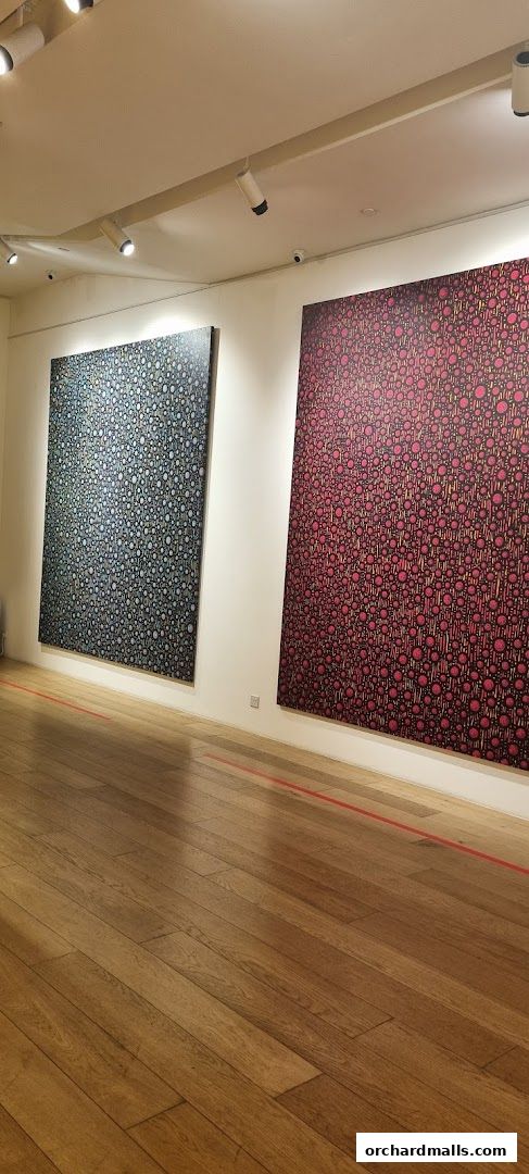 Two large abstract paintings with circular patterns displayed in a well-lit gallery.