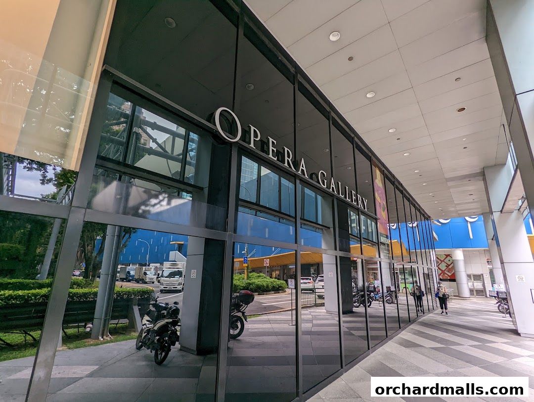 The exterior of Opera Gallery Singapore with large glass windows reflecting the surroundings.