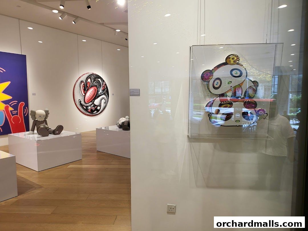 Interior view of an art gallery showcasing contemporary sculptures and paintings.