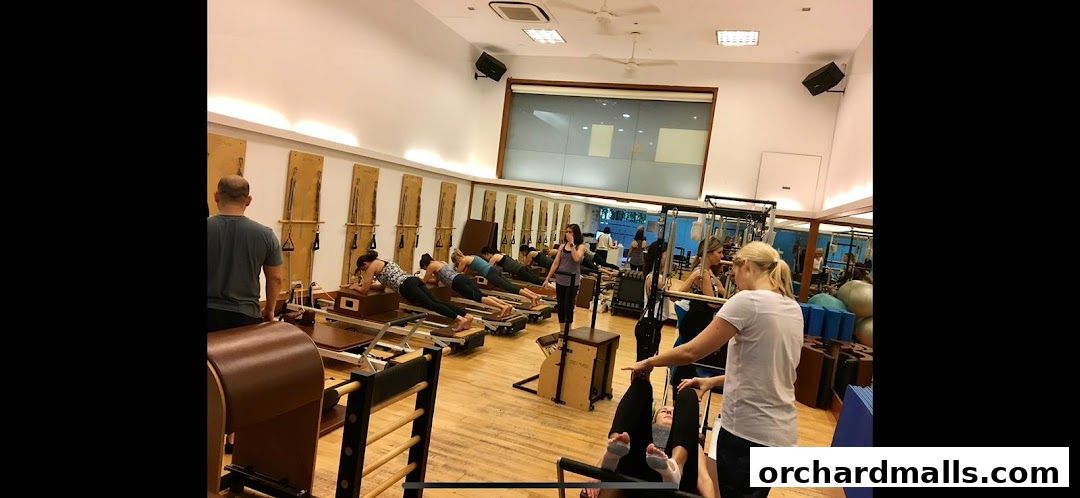 Pilates class in session with instructors and participants using reformers.