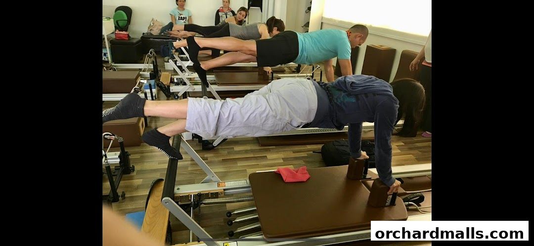 People practicing Pilates on reformers in a studio class.