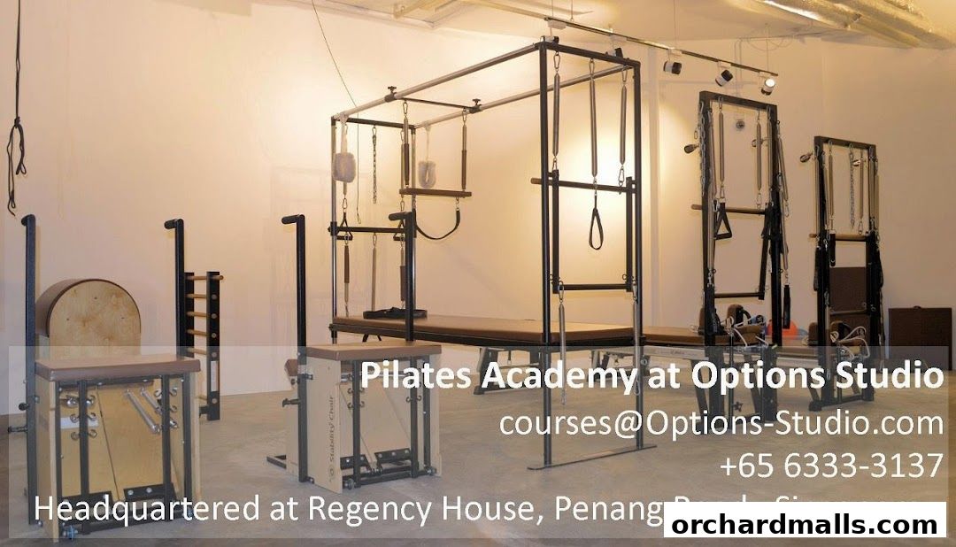 Interior of a Pilates studio with various specialized equipment like reformers and chairs.