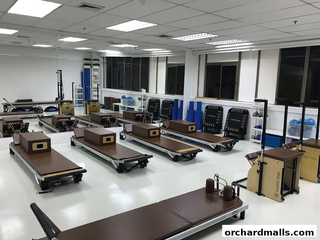 Interior of a well-equipped Pilates studio with reformers and other exercise equipment.
