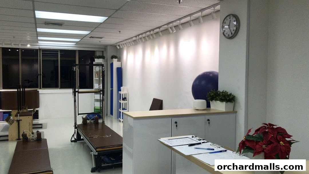 Interior of a Pilates studio with reformers, equipment, and a reception desk.