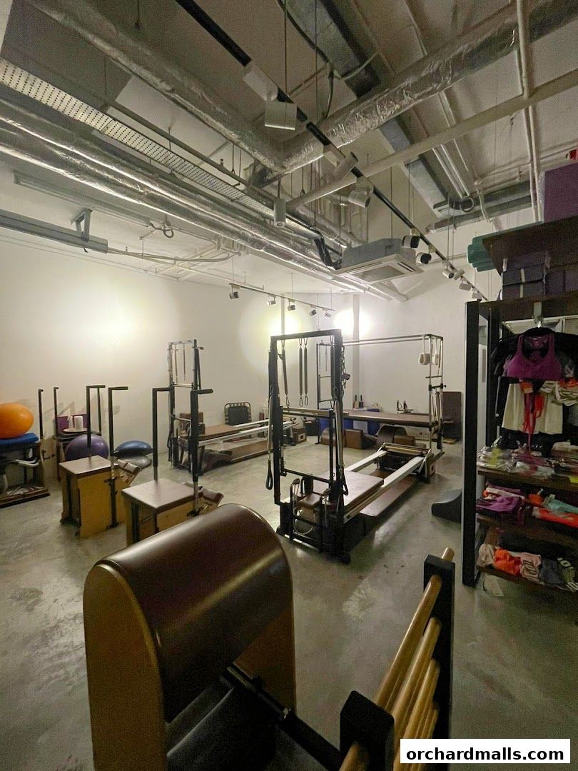 Interior of a Pilates studio with reformers, reformers, and retail items.