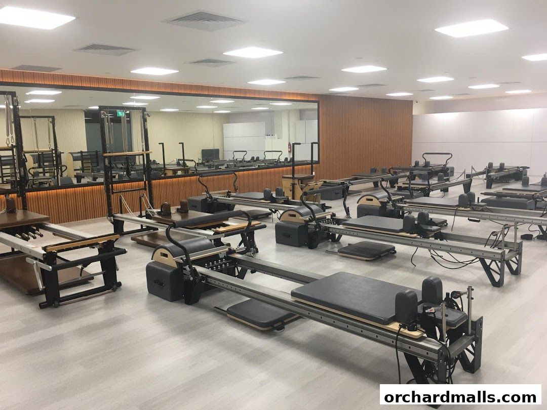 Interior of a modern Pilates studio with multiple reformers and equipment.