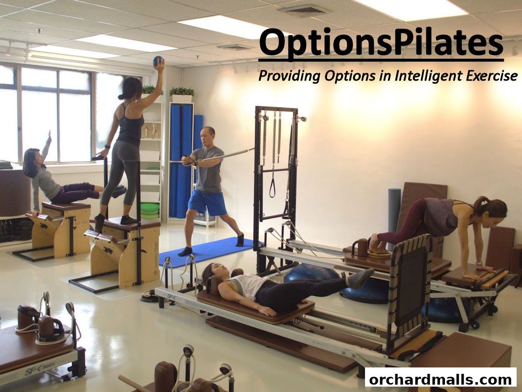 People exercising on Pilates equipment in a bright studio with the studio name displayed.