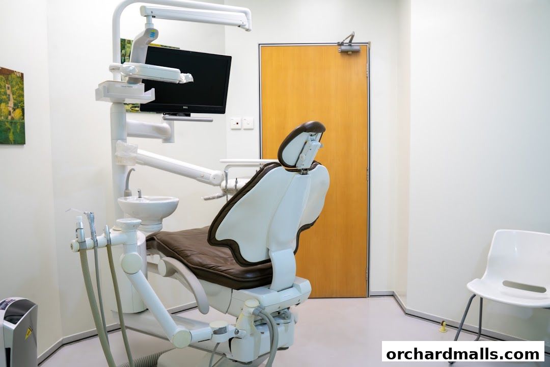 A dental examination chair and equipment in a clean, modern surgery room.
