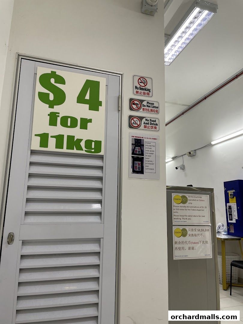 A laundromat with a sign advertising $4 for 11kg wash and token machine instructions.