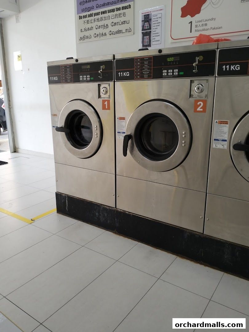 Row of commercial washing machines at Orchard Laundromat Pte Ltd.