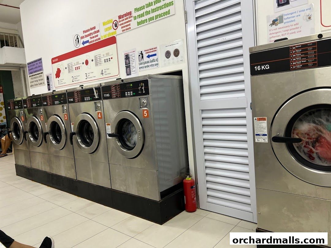 Row of washing machines and a large dryer at Orchard Laundromat Pte Ltd.