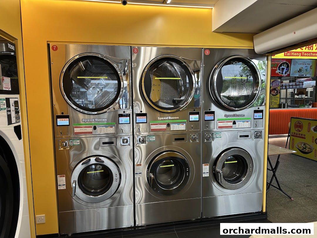 Modern laundromat with multiple Speed Queen washing and drying machines.
