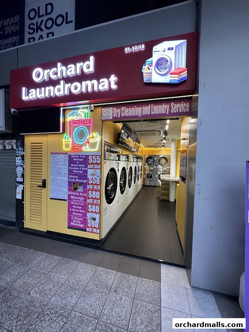 Exterior of Orchard Laundromat, showcasing washing machines and a price list for services.