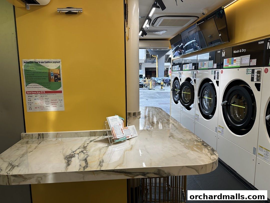 Interior of a laundromat with washing machines and a marble counter.