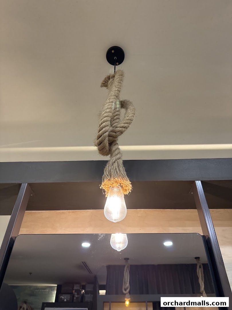 A rustic rope-wrapped pendant light with an Edison bulb hangs from the ceiling.