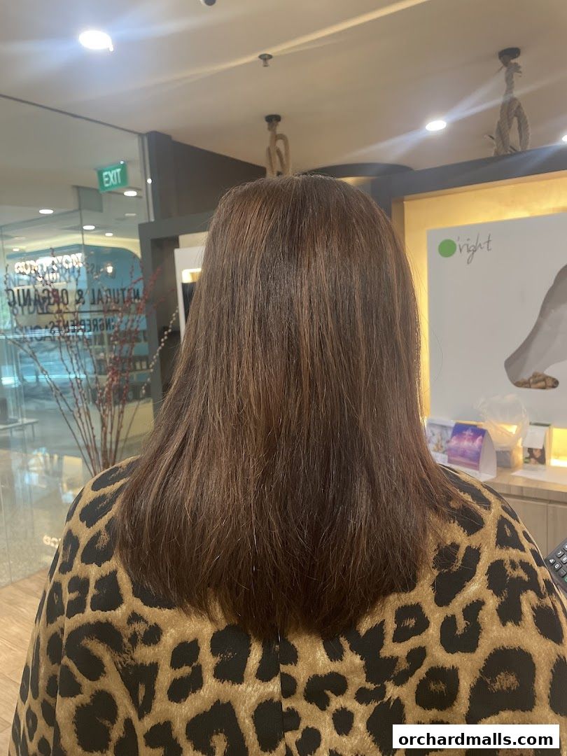 A person's back with healthy, brown hair, wearing a leopard print cape.