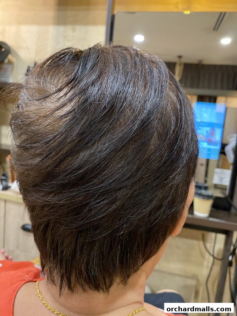 Close-up of a person's short, layered brown hair, showing texture and style.