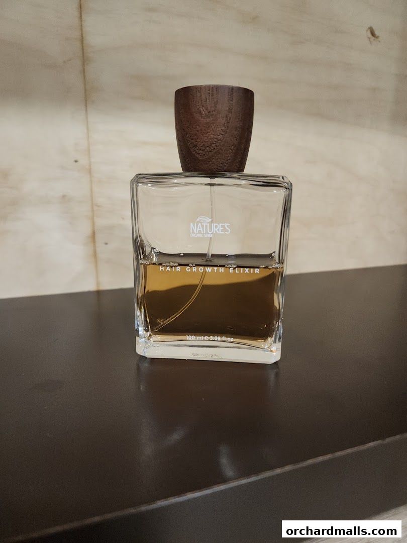 A bottle of Nature's Organic Sense Hair Growth Elixir with a wooden cap.