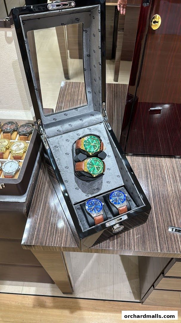 A display case showcasing luxury watches with green and blue faces.