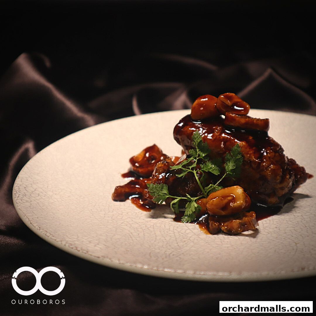 A close-up of a glazed dish with mushrooms and parsley on a textured plate.