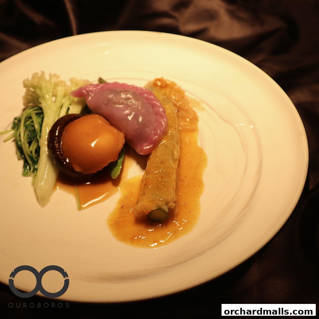 A beautifully plated Chinese dish with a purple dumpling, abalone, and vegetables.