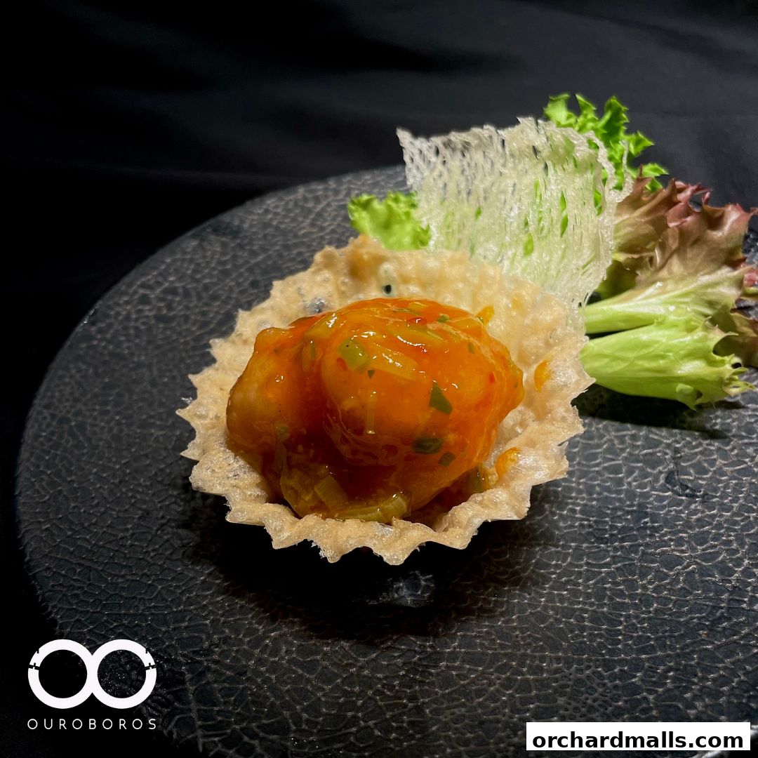 A close-up of a delicious Chinese dish with shrimp in a crispy shell, garnished with lettuce.