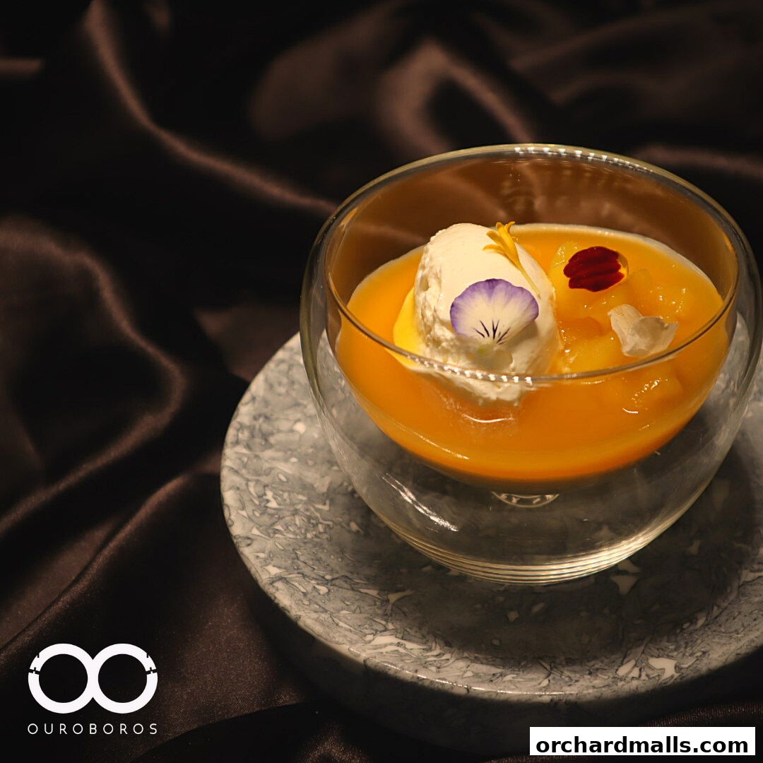 A delicate dessert with ice cream and edible flowers in a glass bowl.
