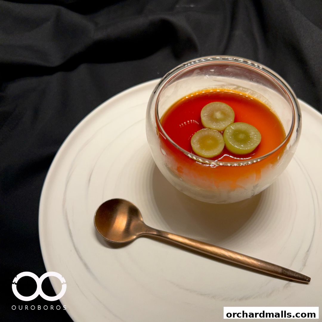 A delicate dessert with grapes and caramel sauce served in a glass bowl.