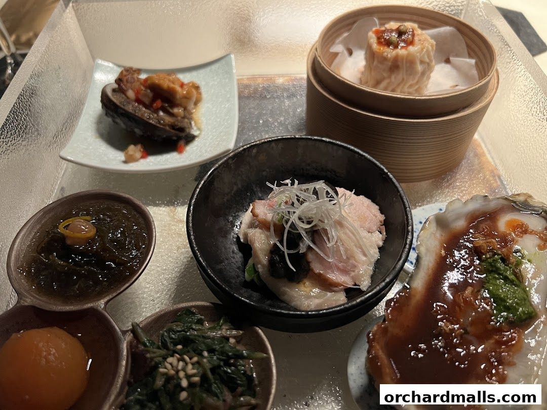 A selection of small Chinese dishes including abalone, dim sum, and oyster.
