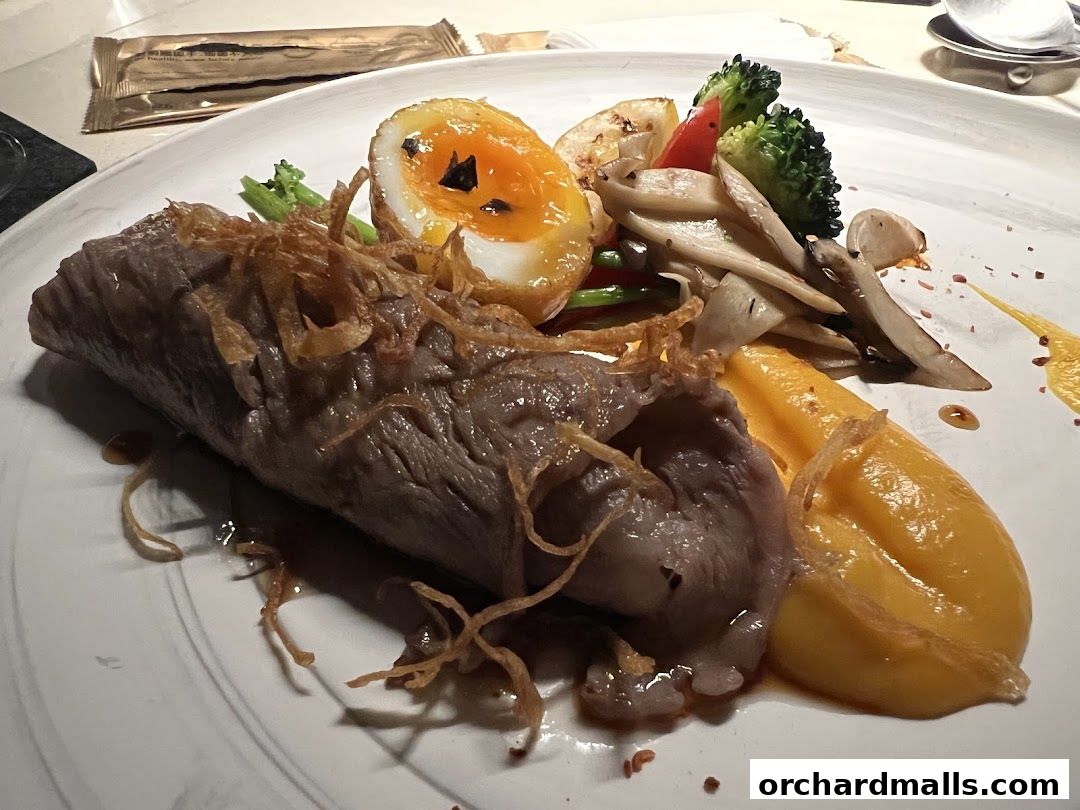 A gourmet dish featuring tender meat, a soft-boiled egg, and assorted vegetables on a white plate.