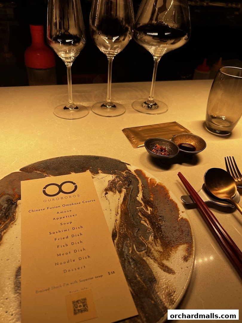 A menu for OUROBOROS Chinese Fusion Omakase Course with wine glasses.