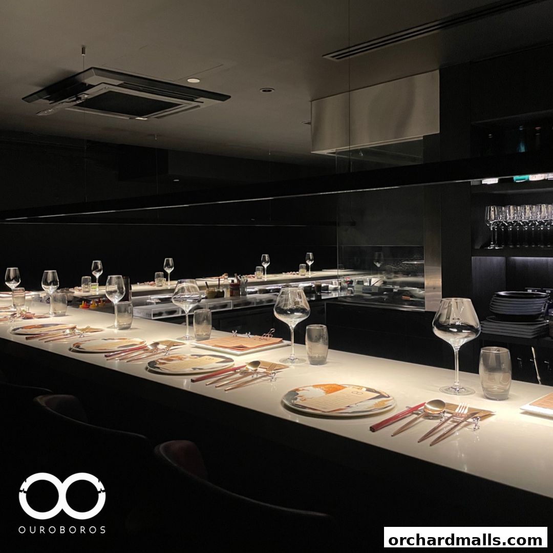Elegant dining counter set with place settings and wine glasses in a modern restaurant.
