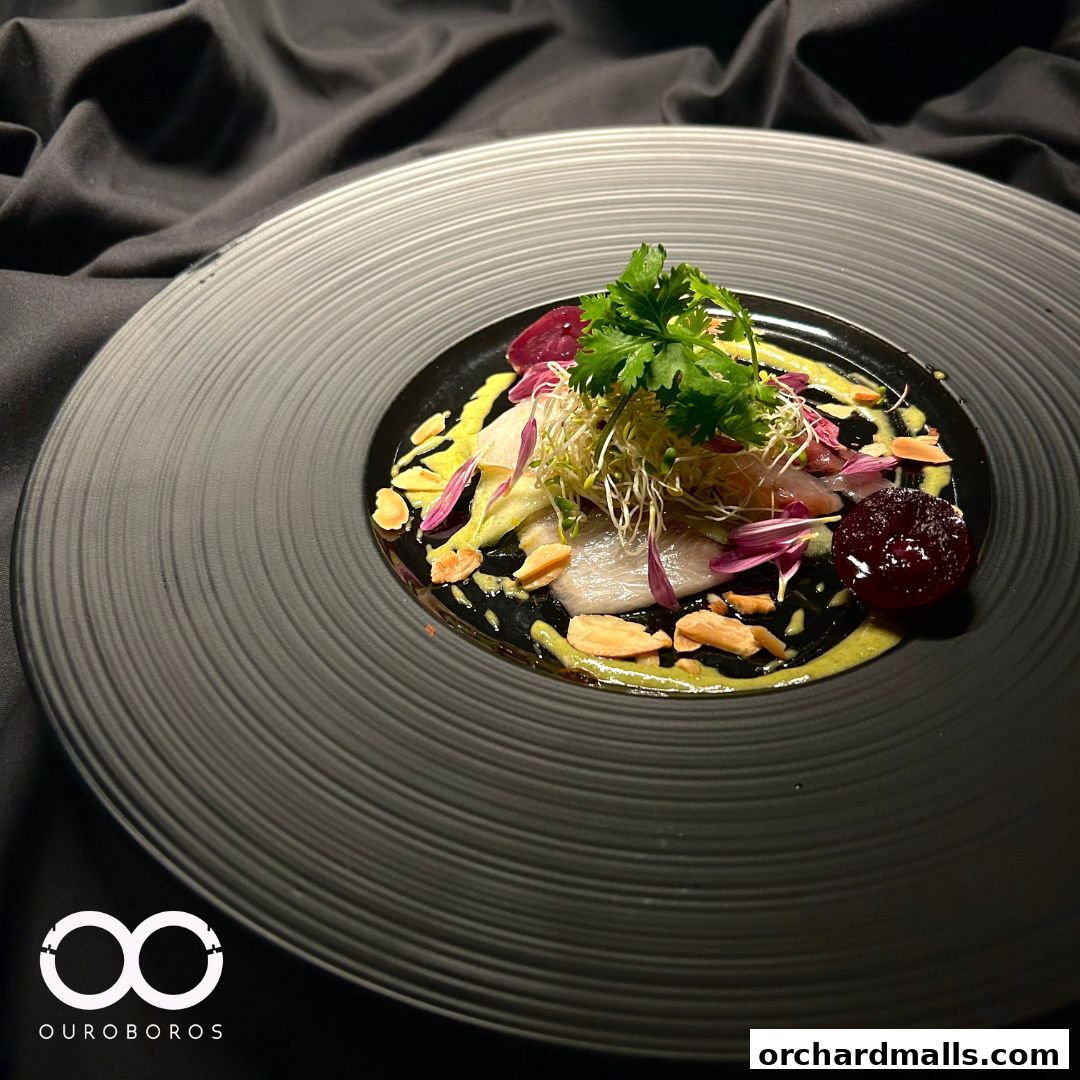 A beautifully plated dish with thinly sliced fish, sprouts, and a beet garnish.