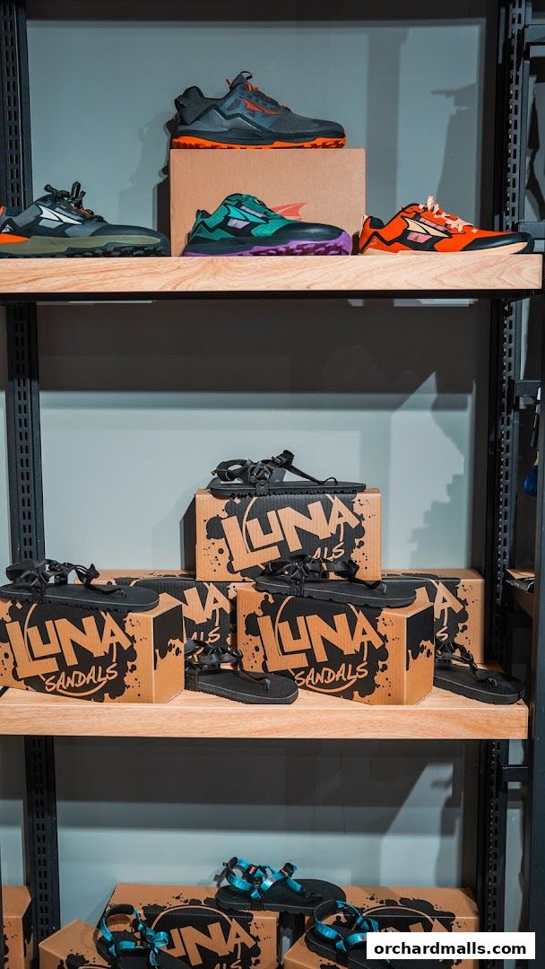 Shelves display various outdoor shoes and sandals from brands like Altra and Luna Sandals.
