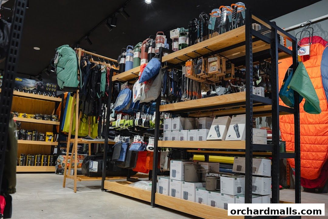 Interior view of an outdoor gear shop with shelves stocked with backpacks, water bottles, and camping equipment.