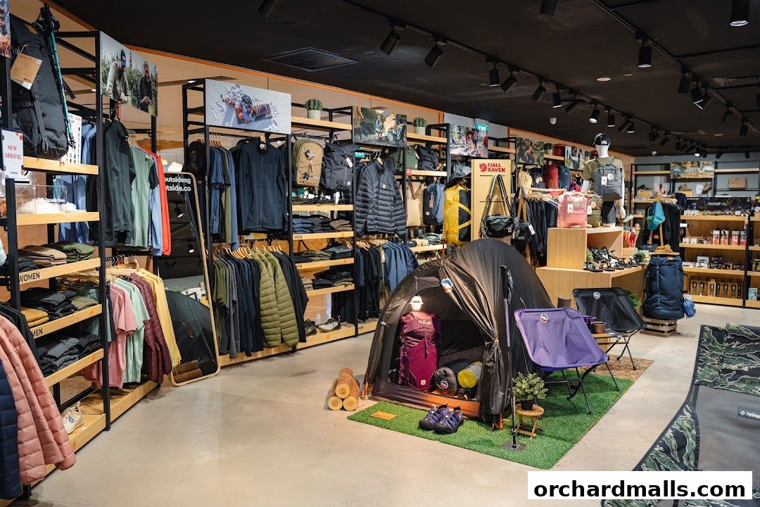 Interior view of an outdoor gear shop with clothing, tents, and camping equipment on display.