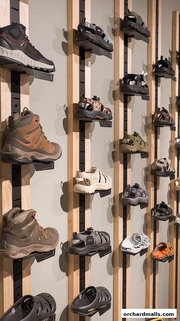 A wall display showcasing a variety of outdoor footwear, including hiking boots and sandals.