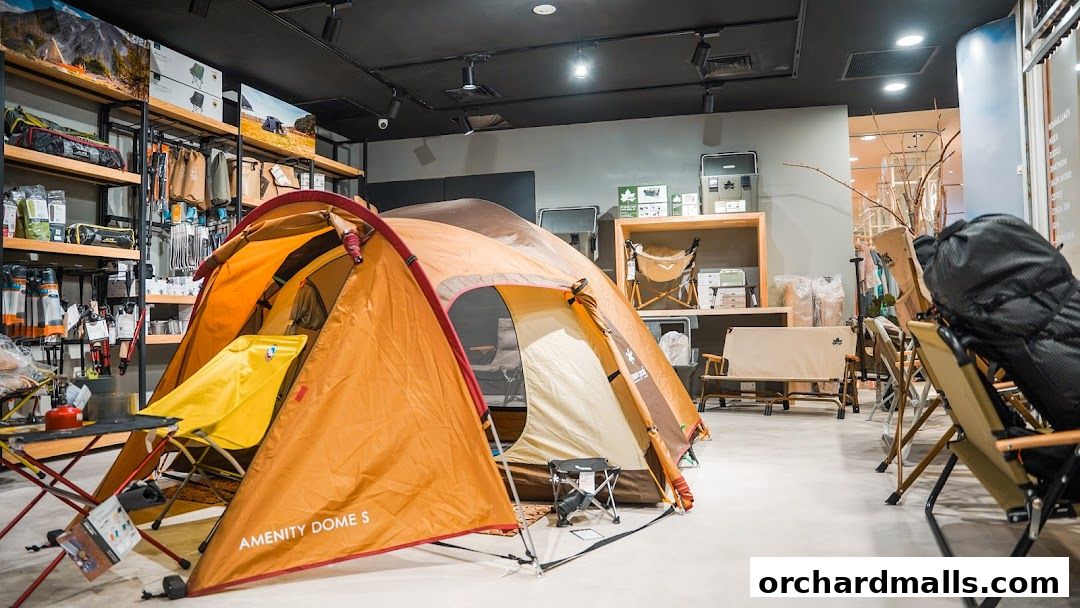 Interior of an outdoor gear shop showcasing tents, camping chairs, and backpacks.