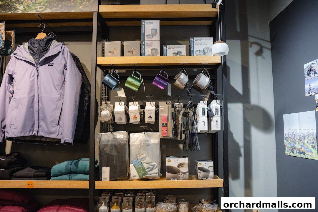 Outdoor gear shop interior with jackets, mugs, cookware, and camping accessories on display.