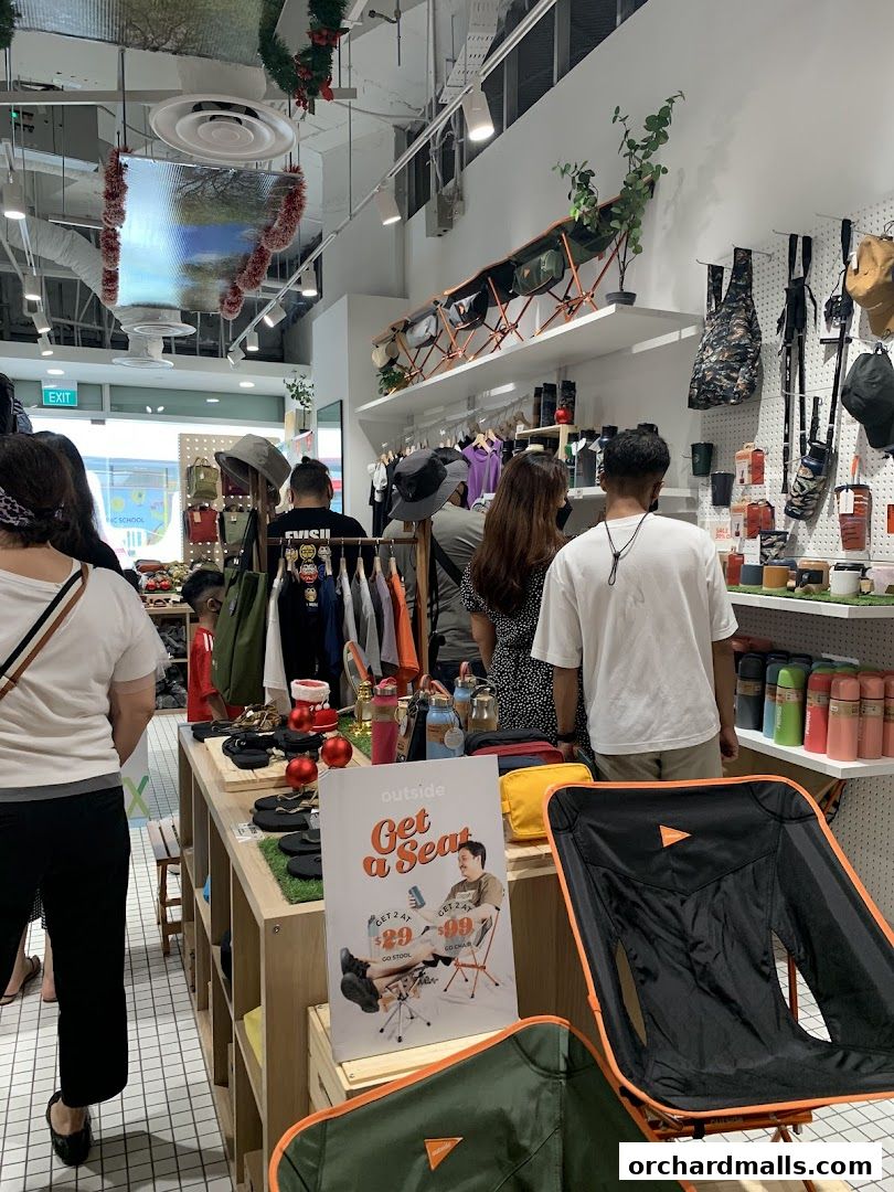 Interior of an outdoor gear shop with camping chairs and accessories on display.