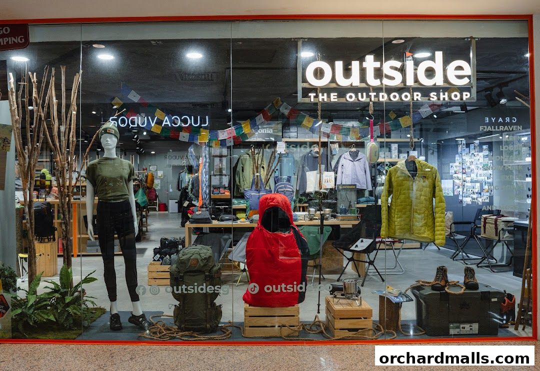 Shop window display for 'Outside The Outdoor Shop' featuring apparel, backpacks, and camping gear.
