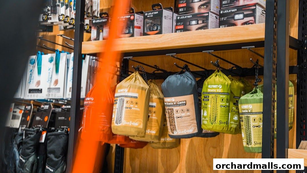 Outdoor gear including sleeping bags and headlamps displayed on shelves and hooks.