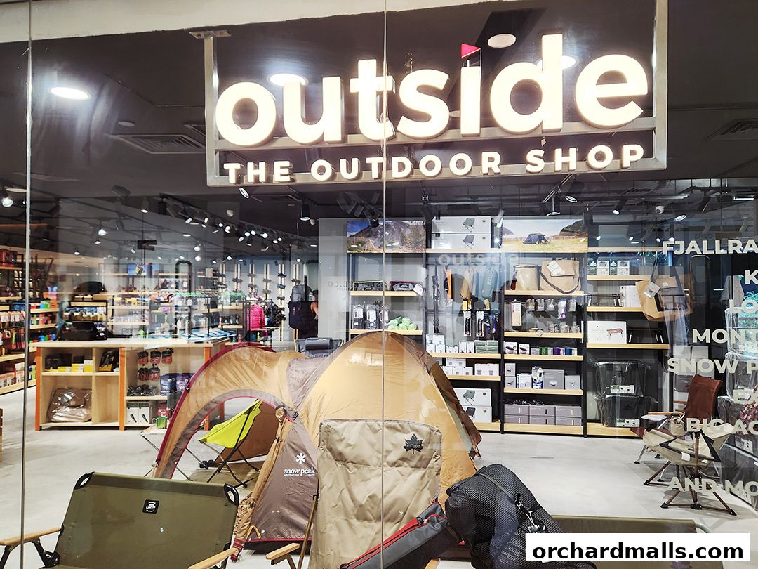 Exterior view of 'Outside The Outdoor Shop' with tents and camping gear displayed.