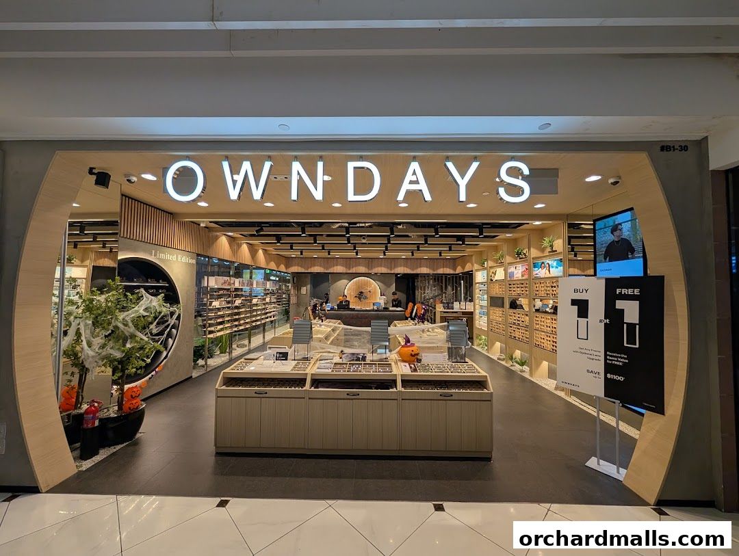 The entrance of OWNDAYS Takashimaya S.C, an eyewear store, showcasing various glasses and a promotional sign.