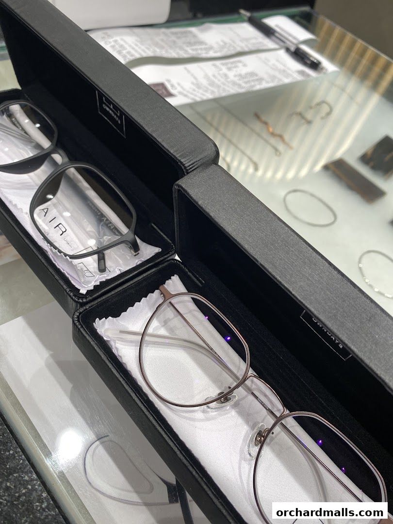 Two pairs of stylish eyeglasses displayed in black cases at OWNDAYS.