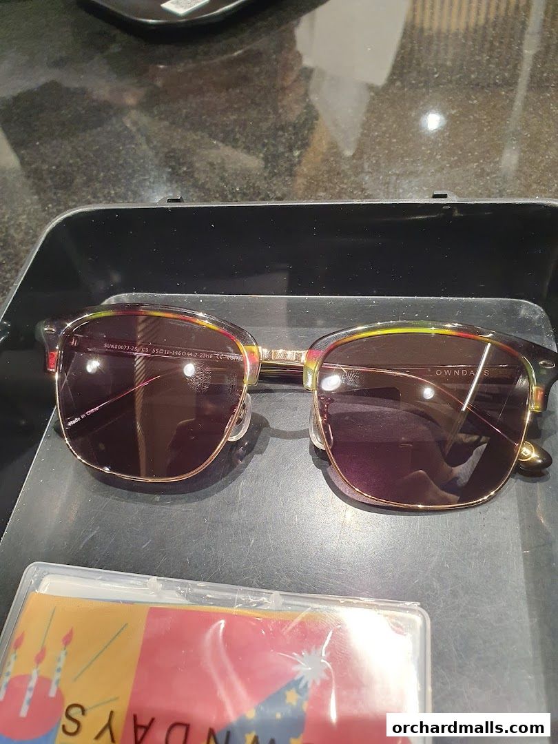 Stylish sunglasses with a colorful frame displayed on a black tray.